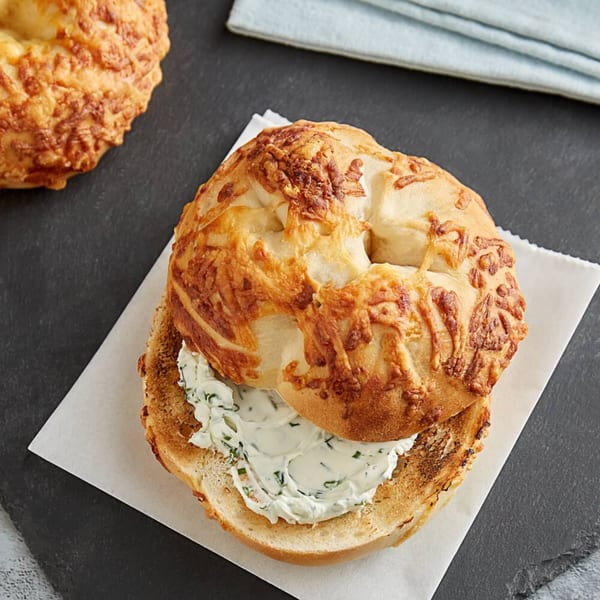 A toasted cheese bagel from Bodega Bros, filled with creamy chive and onion cream cheese.